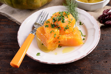 Plate of cooked pumpkin dressed with oil and parsley