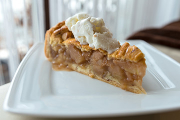Hot apple pie with ice cream on top - concept on a white plate