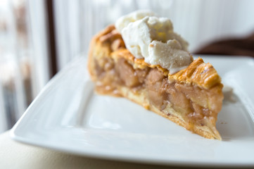 Hot apple pie with ice cream on top - concept on a white plate