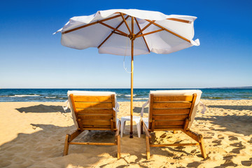 Coastal landscape - Beach umbrellas and loungers on the sandy seashore, the Kavatsi bay near city of Sozopol in Bulgaria