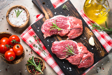 Raw beef steak with herbs. Top view.