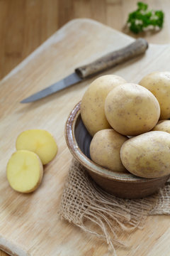 Ungeschälte Kartoffeln auf Holzbrett