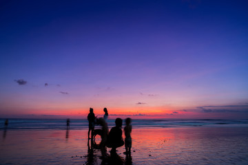 Obraz na płótnie Canvas Beach with people in sunset