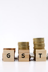GST CONCEPT: Coins and wood plate isolated on white.