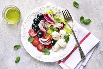 Italian salad caprese with black olive and salad leaves.Top view.