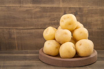 Yellow potato on the wooden background - Solanum phureja
