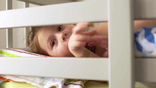 Portrait of adorable little girl having fun and fooling around, while lying in bunk bed in bedroom after awakening
