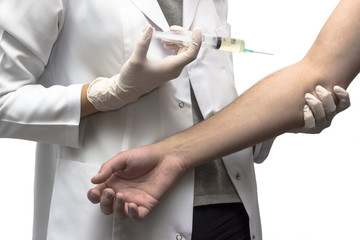 Doctor in white robe ready to make injection in pacient's hand with syringe close up. Medicine and healthcare concept. Selective focus and shallow DOF