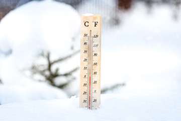 Falling snow in winter and a thermometer.