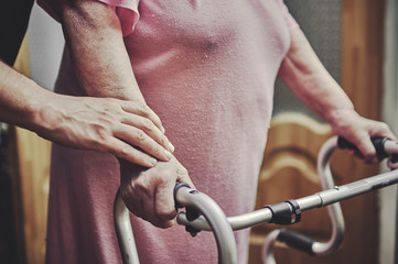 Senior doctor helping his patient to walk