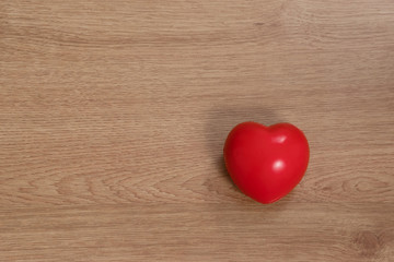 Concept of love in Valentine's Day. Red heart is placed on a wooden floor.