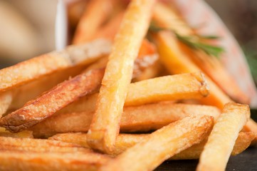 Fast food french fries potatoes with skin served with salt and herbs