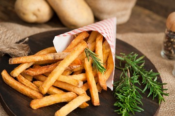 Fast food french fries potatoes with skin served with salt and herbs