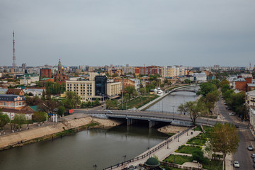 Aerial Astrakhan day cityscape from rooftop. View to bridge through Volga river, historical and modern buildings. Astrakhan downtown