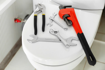 Plumber's tools on toilet seat lid