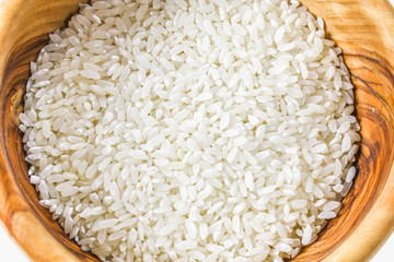 Grains of raw white rice on a white wooden table of boards. Ingredients for cooking.