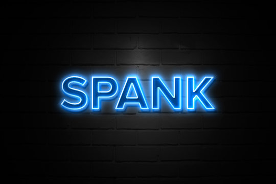 Spank neon Sign on brickwall