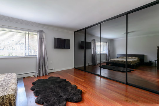 Modern luxury bedroom with a large mirror closet. Interior design.