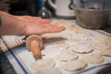 Fototapeta na wymiar Woman preparing pierogi in the kitchen