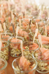 caterer preparing a bunch of glasses with smoked salmon