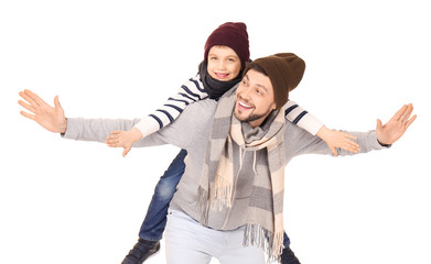 Young man in warm clothing playing with son on white background. Ready for winter vacation