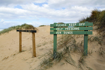 Warning Sign to Please Keep Off the Dunes - to preserve the dunes against erosion. Vegetation and planting marram grass encourages dune growth by trapping and stabilising blown sand. 