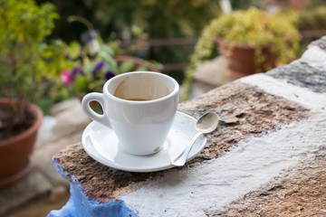A white cup of espresso with spoon.