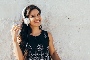 Young woman listening to music via headphones on the street