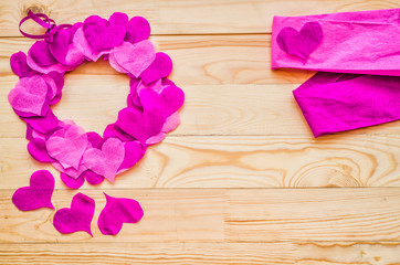 Fototapeta premium valentine day concept. a wreath decorated with purple and pink crepe paper hearts with pink paper with copy space