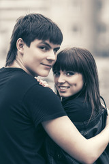 Happy young couple in love hugging in city street