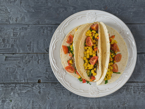 Freshly prepared Mexican tacos on a plate on a table.