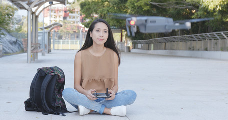 Fototapeta premium Asian Woman control flying drone