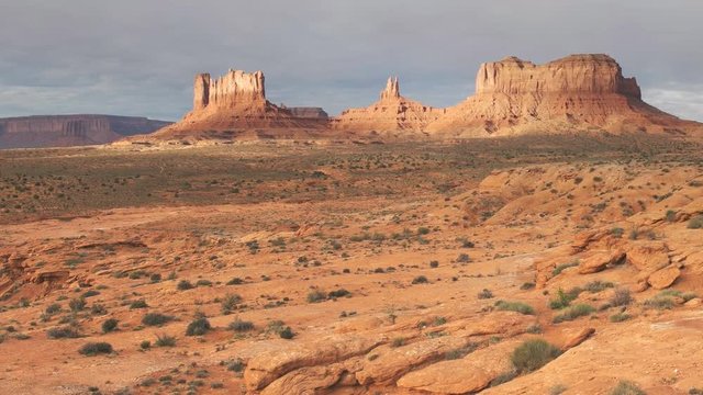 a sunrise panning shot of saddleback mesa at monument valley in utah, usa