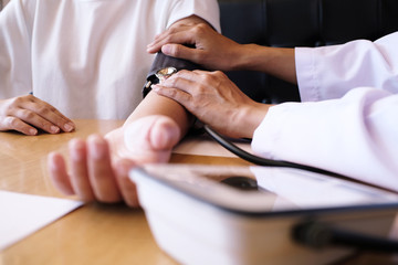 Doctor checking  patient arterial blood pressure. Health care
