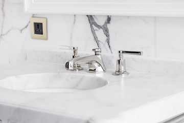 closeup faucet and lavatory white marble restroom interior concept