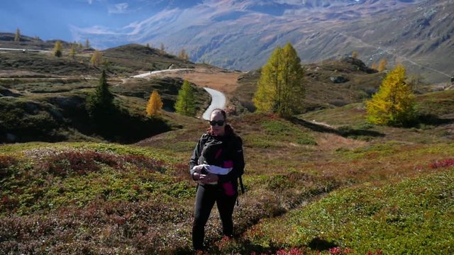 Woman hiking, Cinema 4k Slow motion view of a woman walking in a valley, on a sunny autumn day, on simplon pass, in the swiss alps of Switzerland
