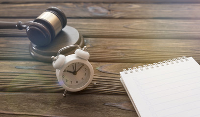 hammer of the judge, alarm clock. notebook on a wooden background. time. law. meeting.