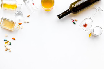 Alcoholism treatment. Glasses, bottles and pills on white background top view copy space