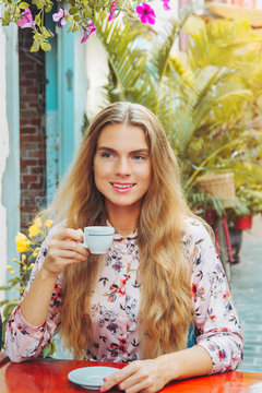 Beautiful woman is enjoying a cup of coffee in the cafe