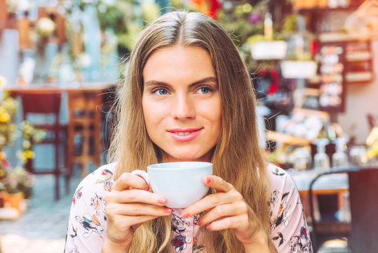 Beautiful woman is enjoying a cup of coffee in the cafe