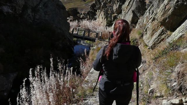 Woman hiking Cinema 4k Handheld view following a woman walking in a valley, on a sunny autumn day, on simplon pass, in the swiss alps of Switzerland