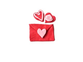 Red envelopes and couple red hearts made from plasticine clay placed on white background, cute Valentine gift dough