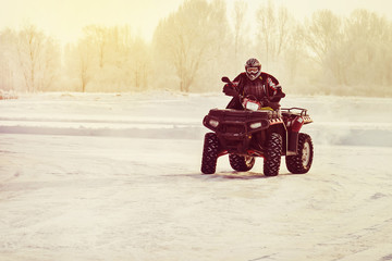 Quad bike driver riding over a frozen lake © diy13