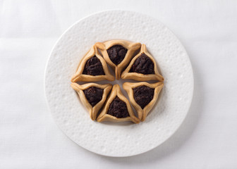 Traditional sweets for Jewish holiday of Purim. Hamantashen cookies or Aman ears, triangular cookies with poppy seeds, top view