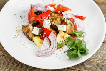 Grilled vegetables salad with red bell pepper, eggplant, onions, feta cheese, peppers, cilantro and tomato.