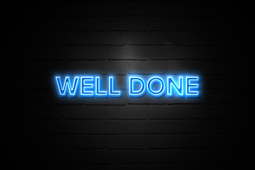 Well Done neon Sign on brickwall