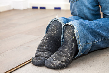 Man laying laminate in socks
