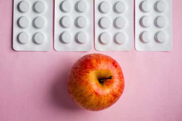 red apple on a tablets background, a natural product as an alternative to medicines_