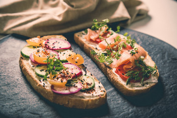 Healthy and tasty toast bread with tomato, radish, salmon fish and cheese on it.
