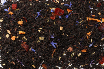 Aromatic black dry tea with petals isolated on white background top view